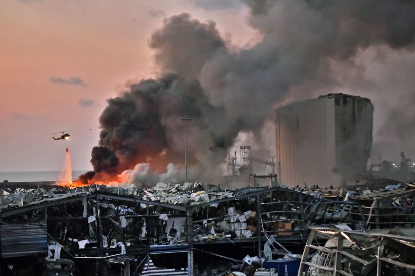 A helicopter dumps water at the site of the explosion on Aug. 4.