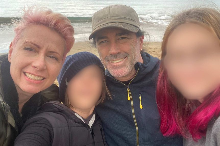 Kathrin, her husband, and their two children on the beach by the sea