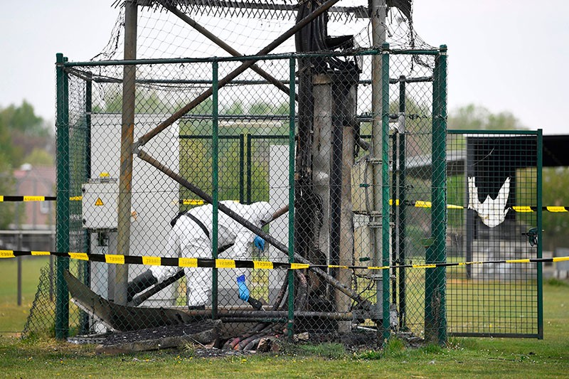 An engineer checks the base of a 5G mast that was set on fire in Belgium