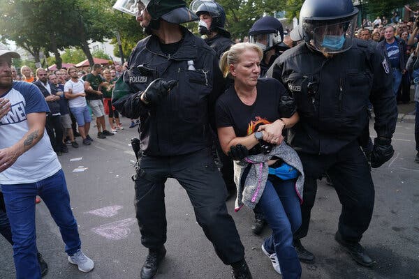 Riot police officers detaining a woman wearing a QAnon T-shirt in Berlin last weekend.