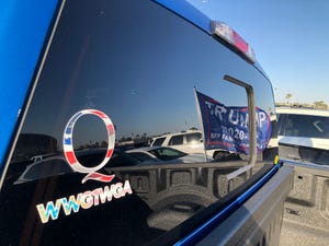 A Q sticker placed on a car parked outside the Veterans Memorial Coliseum ahead of a rally for President Donald Trump on Feb. 19, 2020.