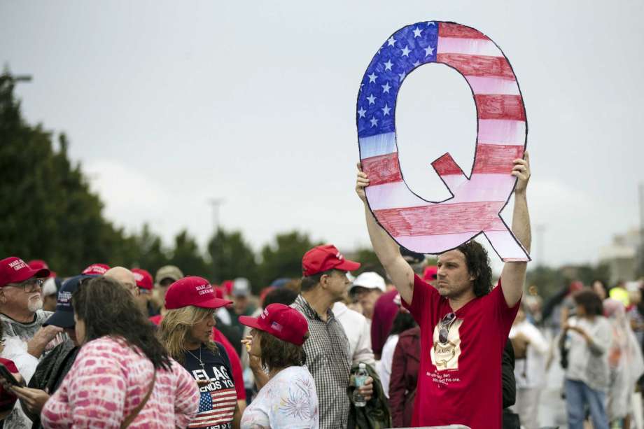 FILE - In this Aug. 2, 2018, file photo, a protesters holds a Q sign waits in line with others to enter a campaign rally with President Donald Trump in Wilkes-Barre, Pa. Facebook and Twitter promised to stop encouraging the growth of the baseless conspiracy theory QAnon, which fashions President Donald Trump as a secret warrior against a supposed child-trafficking ring run by celebrities and government officials. But the social media companies haven’t succeeded at even that limited goal, a review by The Associated Press found. (AP Photo/Matt Rourke, File) Photo: Matt Rourke, STF / Associated Press / Copyright 2018 The Associated Press. All rights reserved.