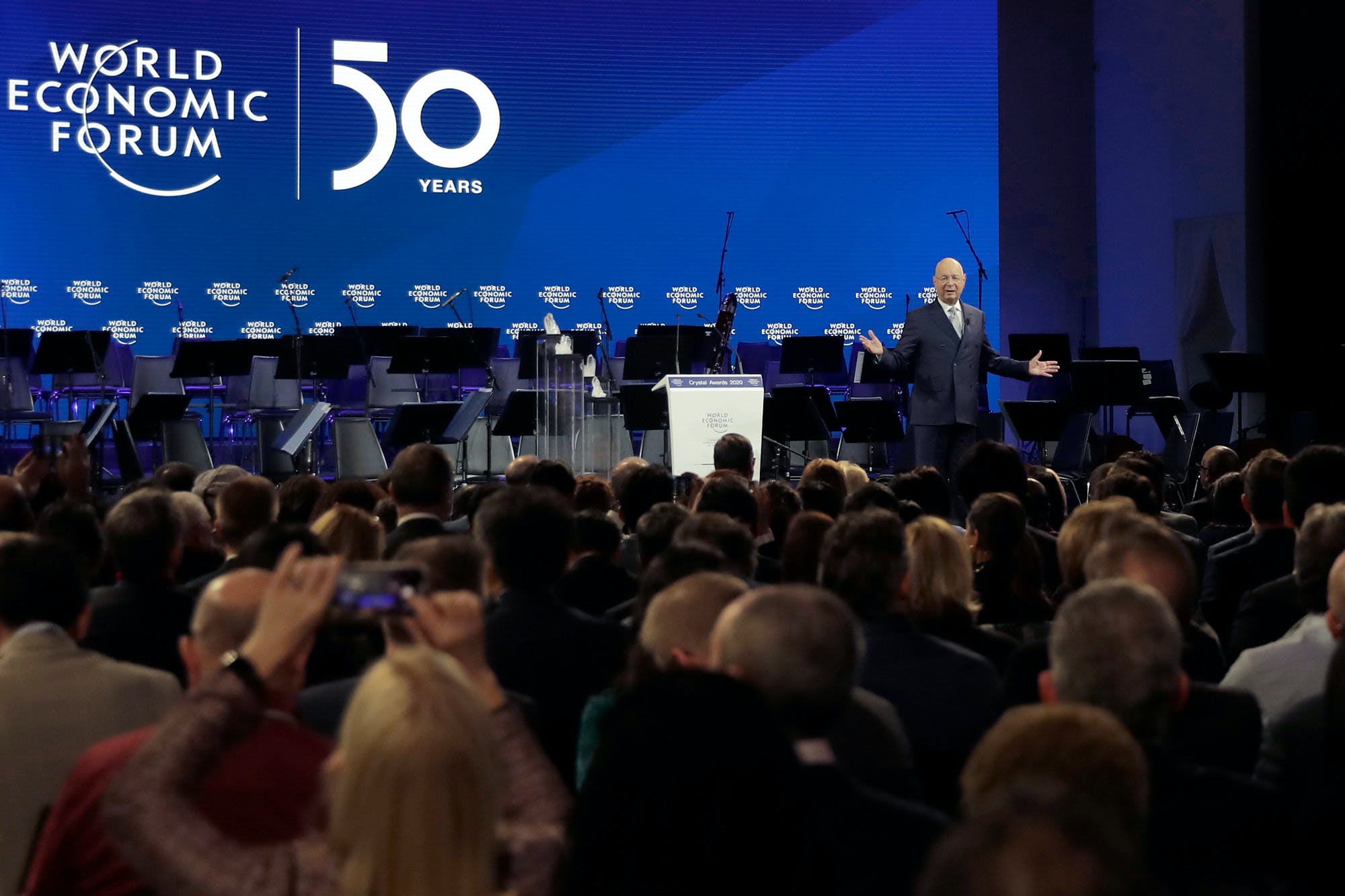 FILE - In this Jan. 20, 2020 file photo,Klaus Schwab, founder of the World Economic Forum, delivers a welcome message on the eve of the annual meeting of the World Forum in Davos, Switzerland. Organizers of the annual World Economic Forum event in Davos, Switzerland, have again changed their planned venue for next year’s edition due to the COVID-19 crisis, announcing it will now take place in Singapore in May and it is expected to return to Davos for the Annual Meeting 2022. (AP Photo/Markus Schreiber, File)