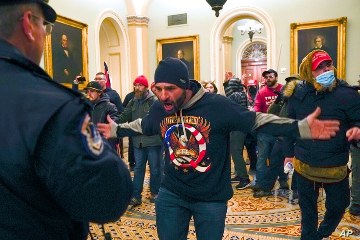 FILE - In this Jan. 6, 2021, file photo, Trump supporters, including Doug Jensen, center, confront U.S. Capitol Police in the…