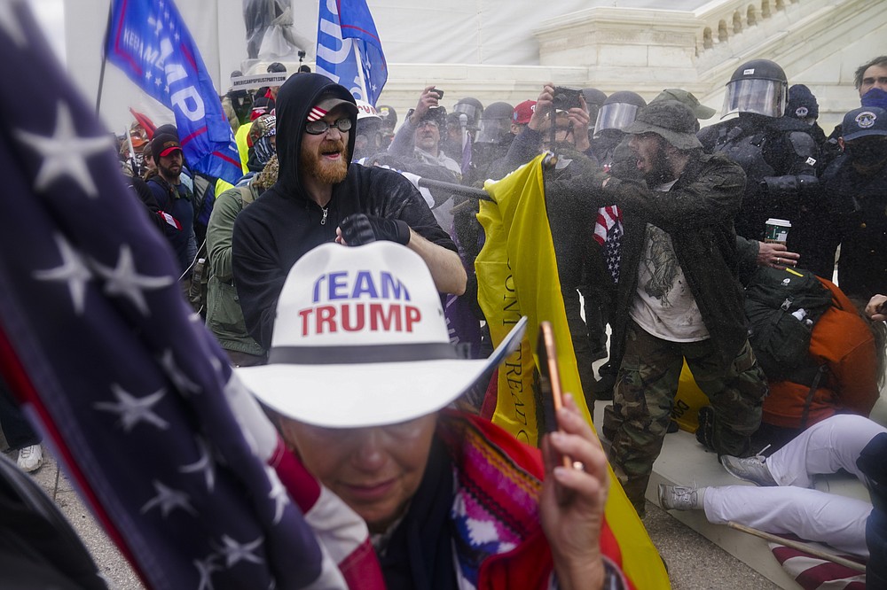 FILE - In this Jan. 6, 2021, file photo violent insurrectionists loyal to President Donald Trump try to break through a police barrier at the Capitol in Washington. Many of those who stormed the Capitol on Jan. 6 cited falsehoods about the election, and now some of them are hoping their gullibility helps them in court. Attorneys for several defendants facing charges connected to the deadly insurrection say they will raise their client's belief in conspiracy theories and misinformation, either as an explanation for why they did what they did, or as an attempt to create a little sympathy. (AP Photo/John Minchillo, File)