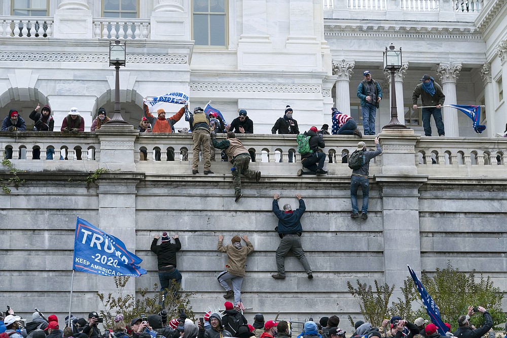 FILE - In this Jan. 6, 2021 file photo, violent insurrectionists loyal to President Donald Trump scale the west wall of the the U.S. Capitol in Washington. Many of those who stormed the Capitol on Jan. 6 cited falsehoods about the election, and now some of them are hoping their gullibility helps them in court. Attorneys for several defendants facing charges connected to the deadly insurrection say they will raise their client's belief in conspiracy theories and misinformation, either as an explanation for why they did what they did, or as an attempt to create a little sympathy. (AP Photo/Jose Luis Magana, File)