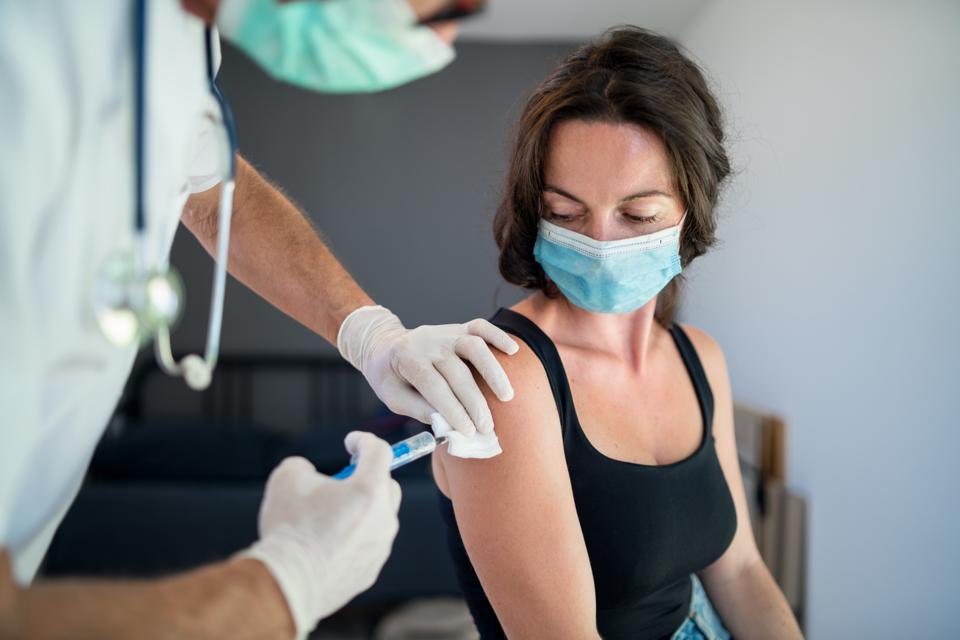 Woman with face mask getting vaccinated, coronavirus.