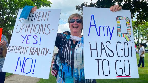 Protesters made signs calling Fachinello "Amy Q" because of the controversy surrounding her QAnon-related posts.