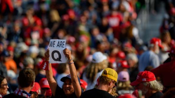 A woman holds up a QAnon sign to the media as attendees wait for President Donald Trump to speak at a campaign rally at Atlantic Aviation on September 22 in Moon Township, Pennsylvania. 