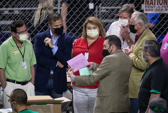 Wisconsin state Rep. Janel Brandtjen, center, former Missouri Gov. Eric Greitens, second from left, and Wisconsin state Rep. Dave Murphy, left, watch as Maricopa County ballots from the 2020 presidential election are examined and recounted by contractors hired by the Arizona Senate on June 12, 2021, at Veterans Memorial Coliseum in Phoenix. Election Audit 13p1