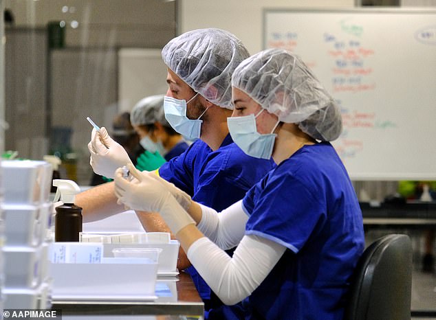 Health workers prepare Pfizer vaccinations at the Melbourne Convention and Exhibition Centre mass vaccination hub