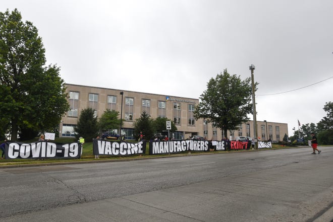 Protesters gather across from the Hamilton County Public Health building in the Corryville neighborhood of Cincinnati, displaying anti-vaccine signs to passing cars on William Howard Taft Road on Monday, Aug. 9, 2021.