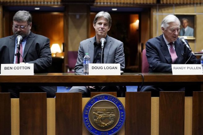 Cyber Ninjas CEO Doug Logan, center, is flanked by Ben Cotton, left, founder of digital security firm CyFIR, and Randy Pullen, right, the former Chairman of the Arizona Republican Party, prior to the Arizona Senate Republicans hearing review of the 2020 presidential election results in Maricopa County at the Arizona Capitol, Friday, Sept. 24, 2021, in Phoenix. (AP Photo/Ross D. Franklin)