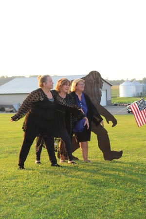 Sisters and authors (left to right) Mary Tipton, Cheryl Fields and Shelly Spade pose with a Bigfoot sign in Wayne County. The three sisters recorded paranormal stories that include Bigfoot, UFO sightings and ghosts around Holmes County in their new book "Holmes County Hair Raisers."