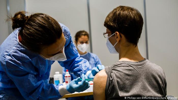 doctor administering COVID jab to a young patient