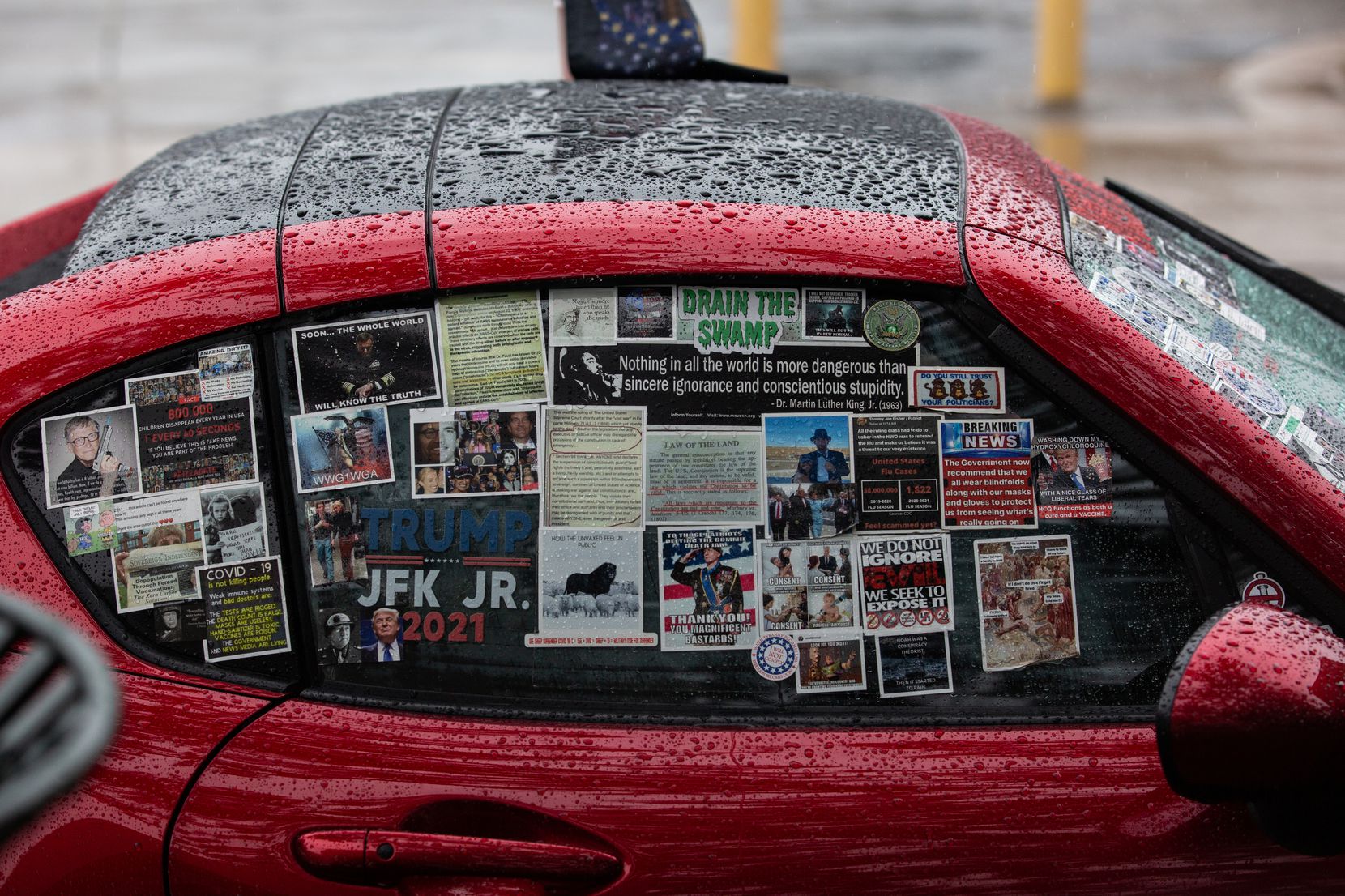 A car covered in QAnon and Trump stickers sits at a QAnon gathering at Dealey Plaza in downtown Dallas on Nov. 2.