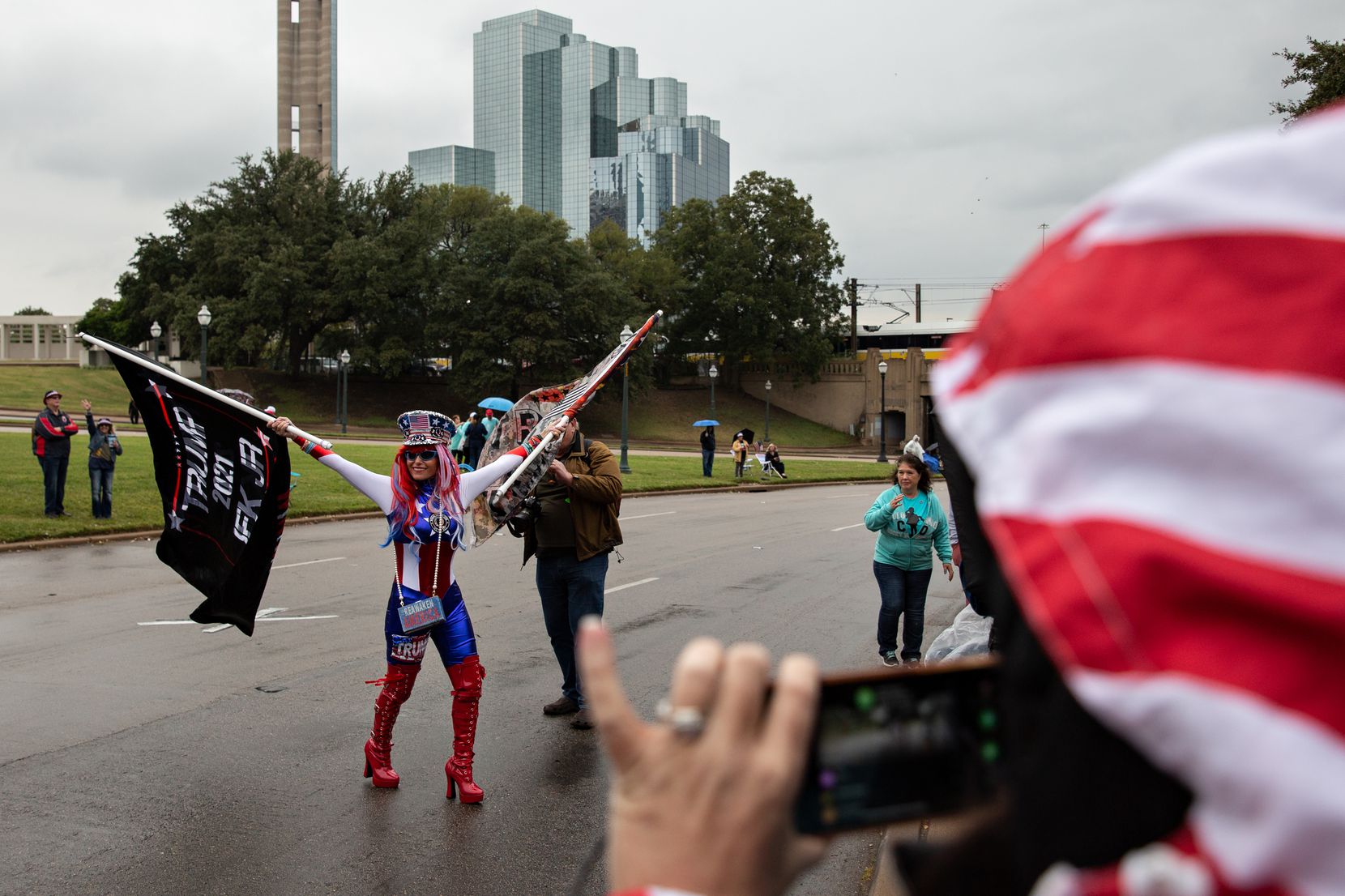 Micki Larson-Olson waves two Trump flags in the street alongside Dealey Plaza during a QAnon gathering on Nov. 2.