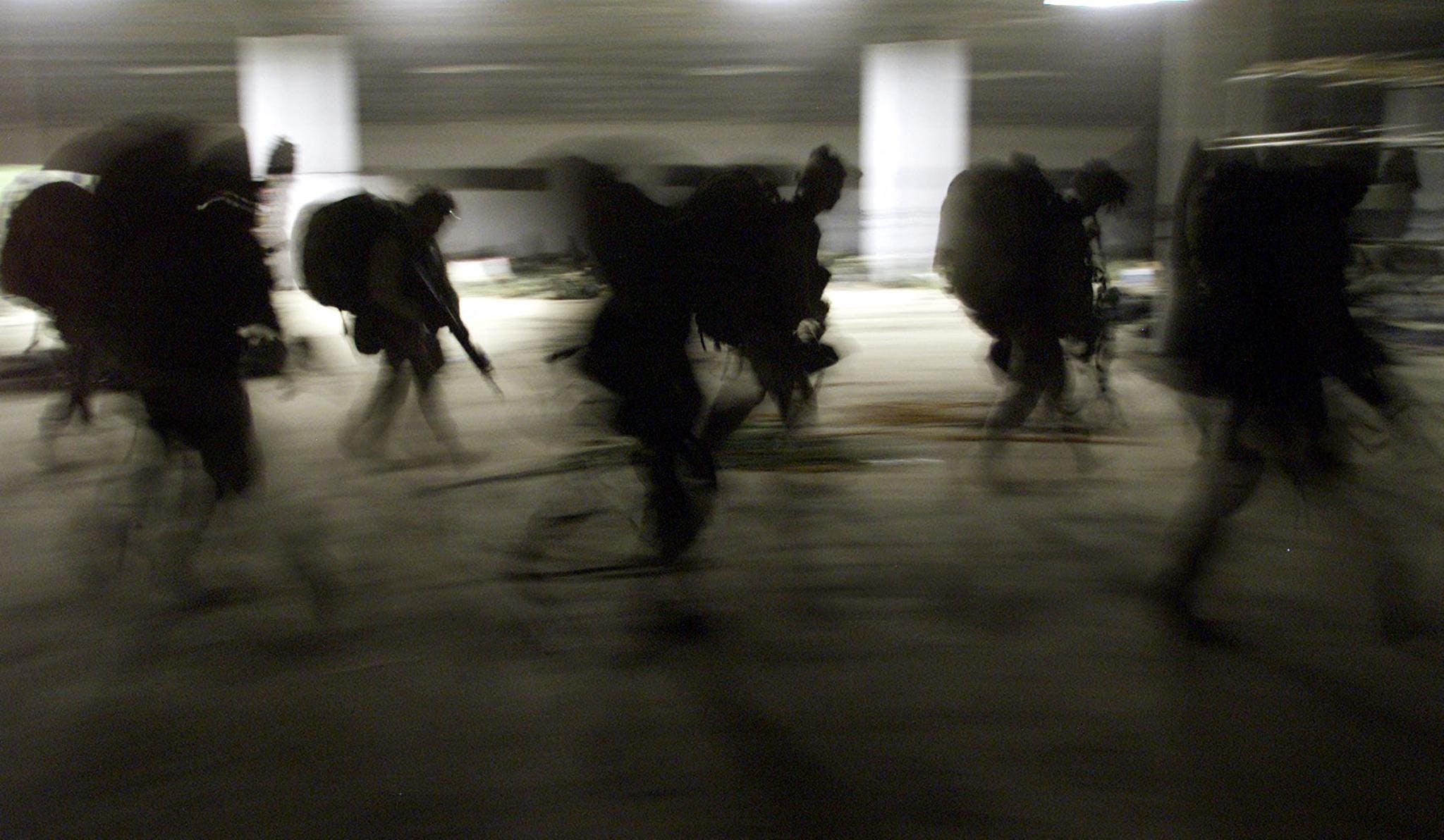 In this file photo taken on November 29, 2001 United States Marines from Bravo Co. of the 15th MEU (Marine Expeditionary Unity) march into the barracks in full battle gear as they arrive very early morning at the US Marines forward base in southern Afghanistan. - Launched in the wake of the September 11 attacks, the war in Afghanistan claimed the lives of tens of thousands of Afghans along with around 2,400 US soldiers and saw trillions squandered in what has largely been deemed a failed nation-building project. (Photo by JIM HOLLANDER / POOL / AFP) (Photo by JIM HOLLANDER/POOL/AFP via Getty Images)