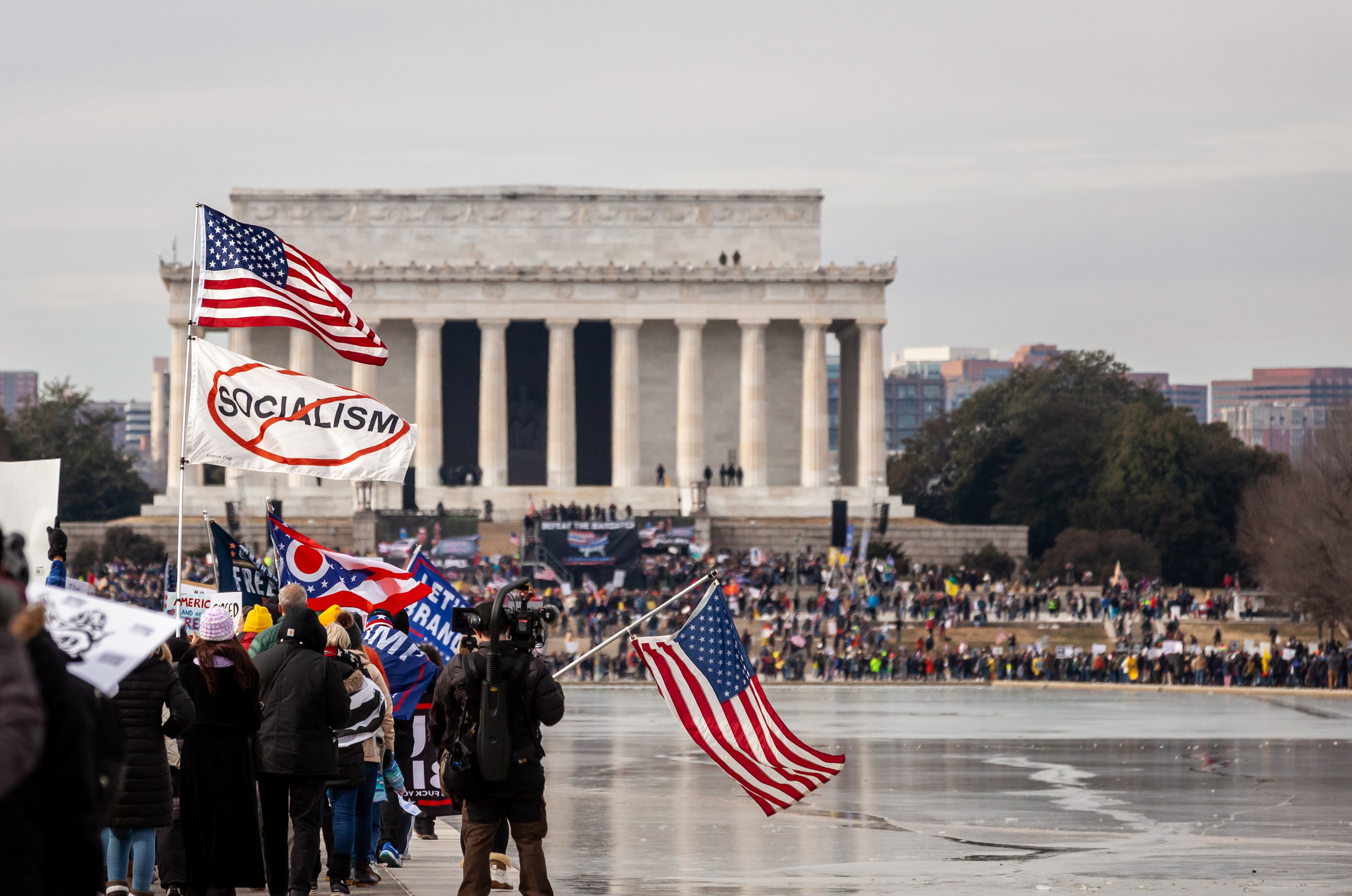 A protester carries American and anti-socialism flags during the Defeat the Mandates rally and march in Washington, DC. Organizers and attendees claim that vaccines and mask-wearing should be a personal choice