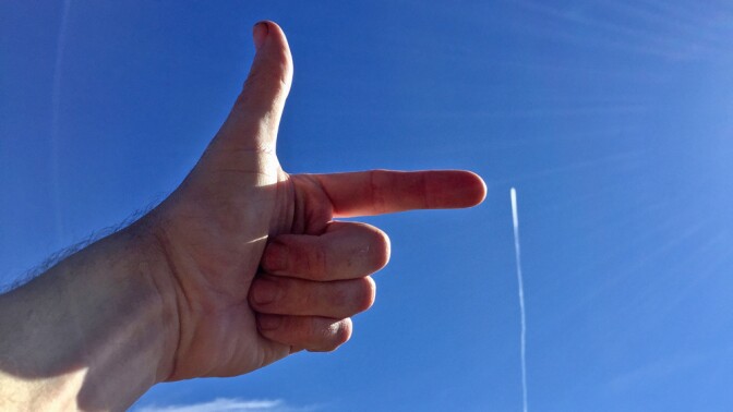 Hand pointing at a contrail | Photo: Stuart Anthony, some rights reserved