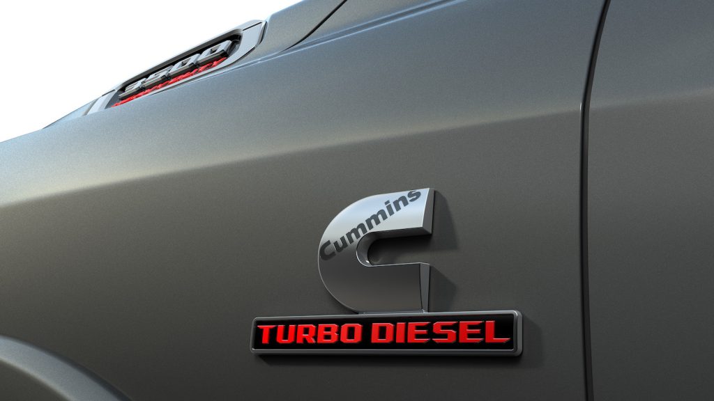 Closeup of a Cummins turbo diesel badge on the fender of a Ram pickup truck.