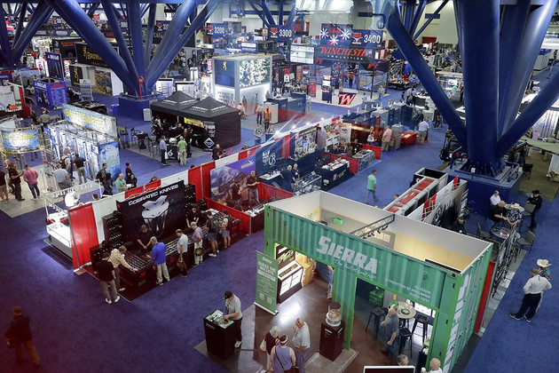 People walk through the main exhibition hall at the National Rifle Association Annual Meeting.