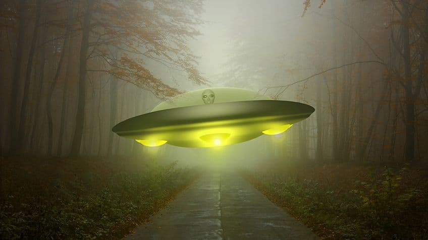 A glowing UFO flying low through a forest