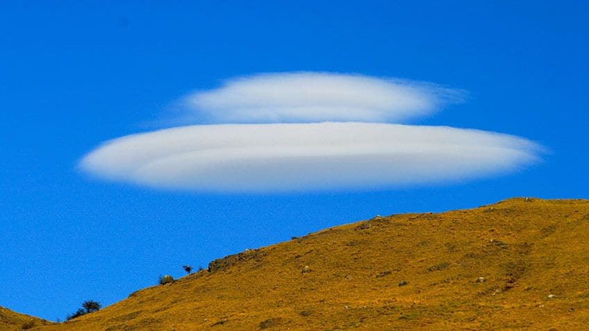 Two clouds that appear to be shaped liked UFOs