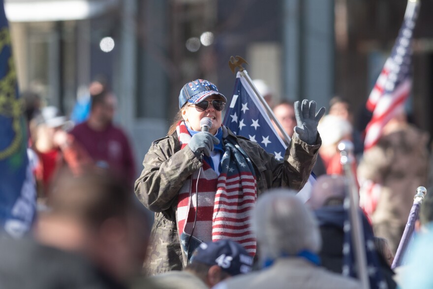 Nevada state Senate candidate Monica Jaye speaks at a pro-Trump rally wearing sunglasses and an American flag scarf.