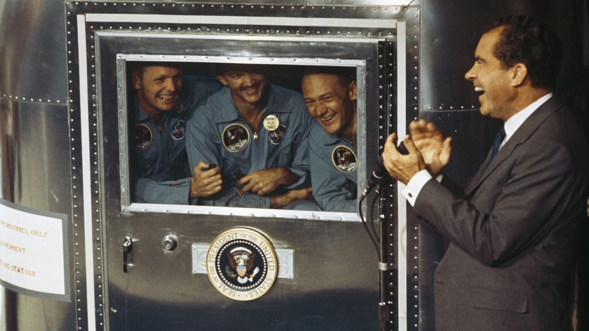 President Richard Nixon speaking with Apollo 11 crew members Neil Armstrong, Michael Collins and Buzz Aldrin who were subjected to a period of quarantine upon their return to Earth.