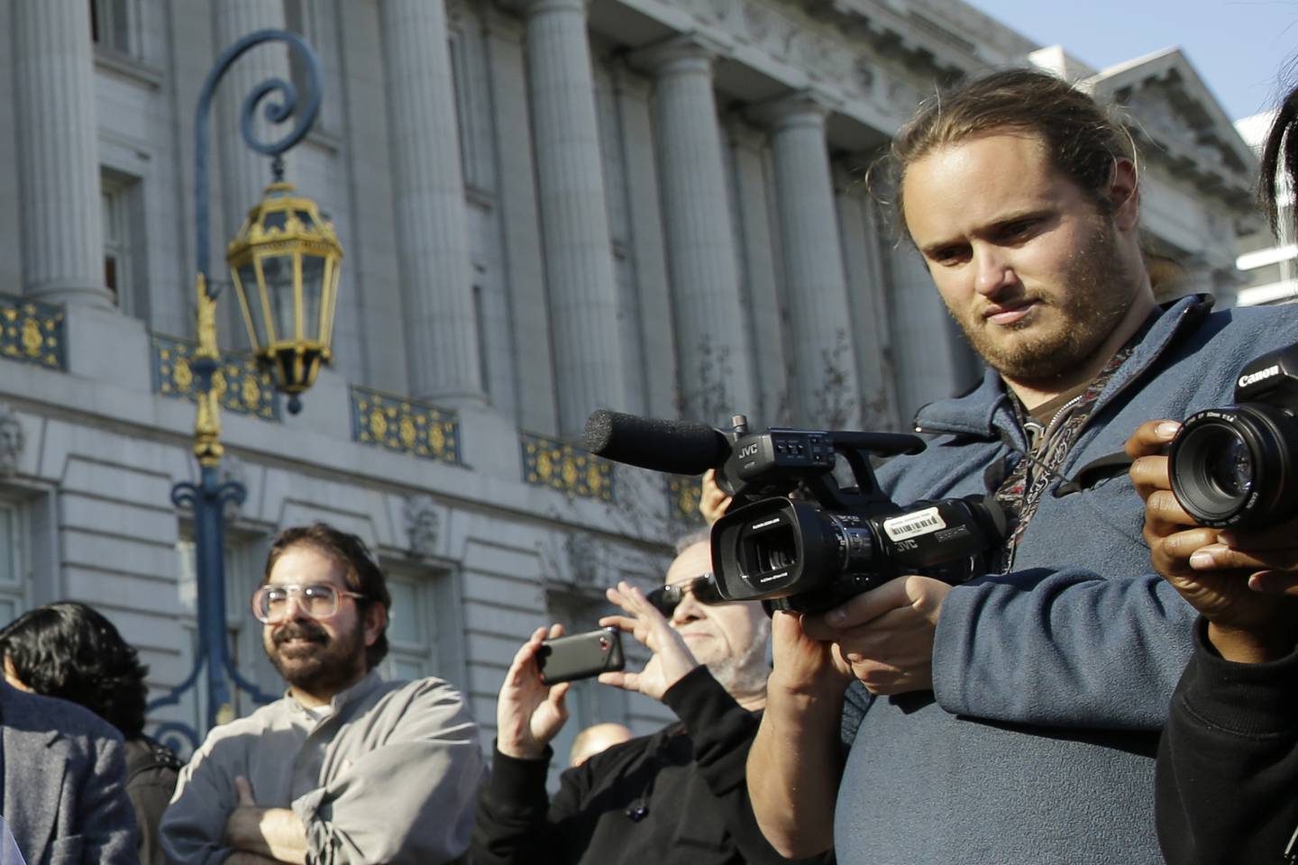 David DePape, right, records the nude wedding of Gypsy Taub outside City Hall on Dec. 19, 2013, in San Francisco. DePape, accused of breaking into House Speaker Nancy Pelosi's California home and severely beating her husband with a hammer, appears to have made racist and often rambling posts online.