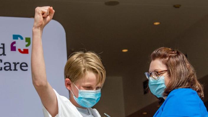 A boy celebrates being inoculated in Hartford, Connecticut on May 13, 2021, as part of a clinical trial of the Pfizer vaccine earlier this year.