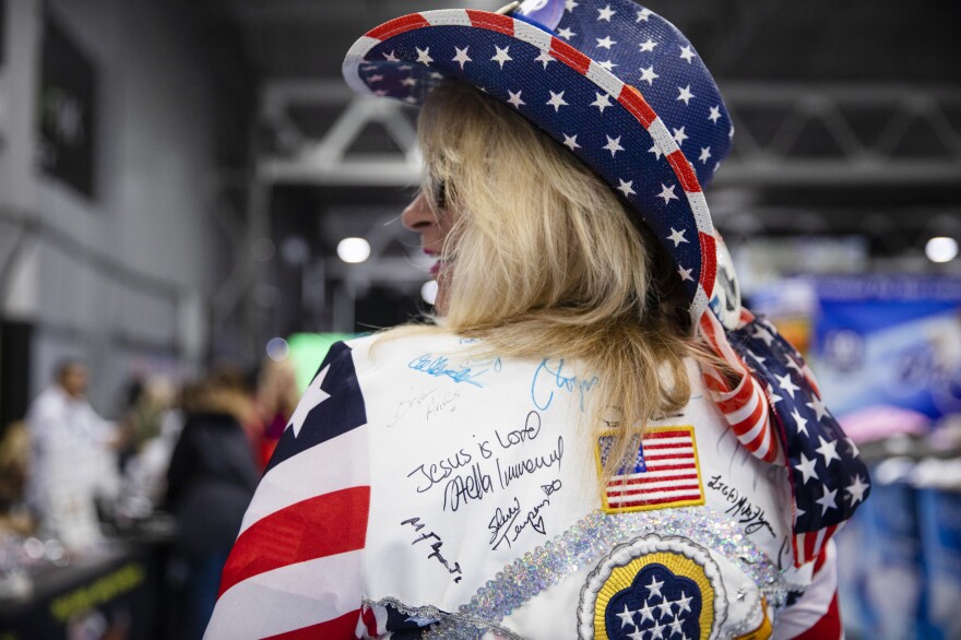 Deborah from New York City poses for a photo in her "good vibes jacket" during the ReAwaken America Tour held at the Spooky Nook Sports complex in Manheim, Pa. on Friday, Oct. 21, 2022.