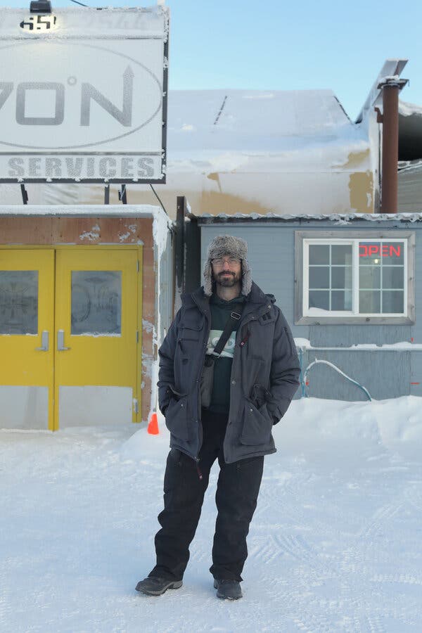 Sam Lyman standing in snow in front of a building.