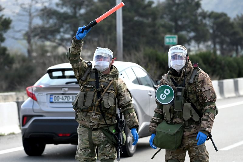 Georgian soldiers wearing protective masks stop a car at a checkpoint in Tbilisi on April 1, 2020 amid concerns over the spread of the coronavirus.