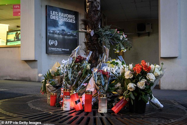 Flowers and candles next to the building that the five members of a French family jumped from