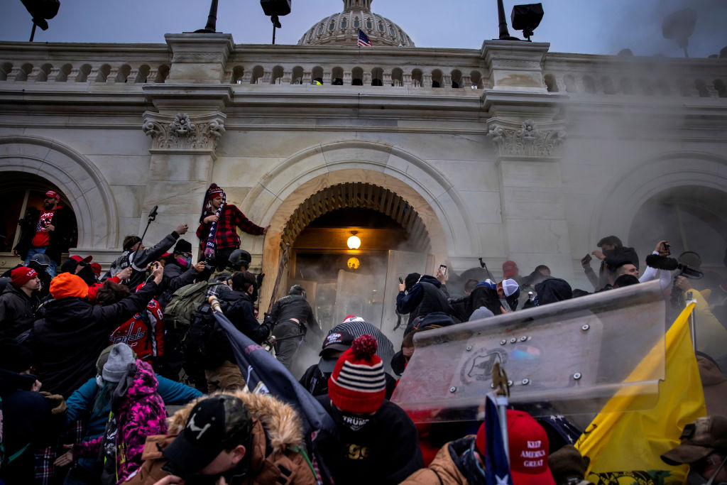 A picture of the Capitol riots, which saw people storm the Capitol building in Washington DC. The image shows people flooding through the doors of the building.