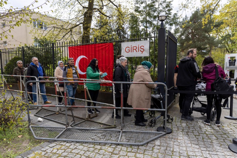 Turkish citizens wait in line outside the consulate during early voting in the Turkish general elections in Berlin.