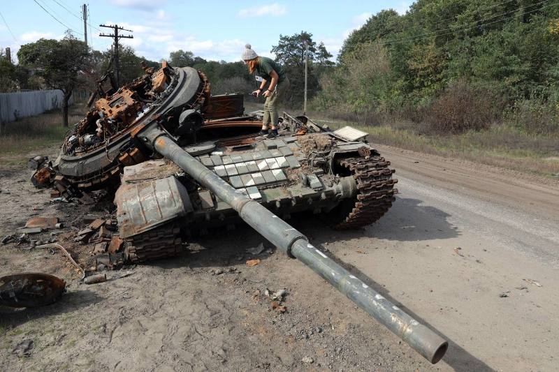 A girl stands atop a destroyed Russian tank.