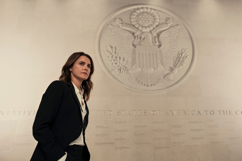 Keri Russell as Kate Wyler walks by a State Department Seal from a scene in The Diplomat, a new Netflix show about the foreign service.