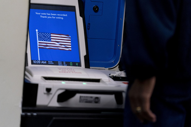 A voter submits their ballot at an early voting location in Alexandria, Va., on Sept. 26, 2022. 