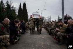 Ukrainian servicemen of the Khartia battalion carry the coffin of Vladyslava "Aida" Chernyh during a funeral ceremony in Kharkiv on December 30, 2022. (Evgeniy Maloletka/AP)