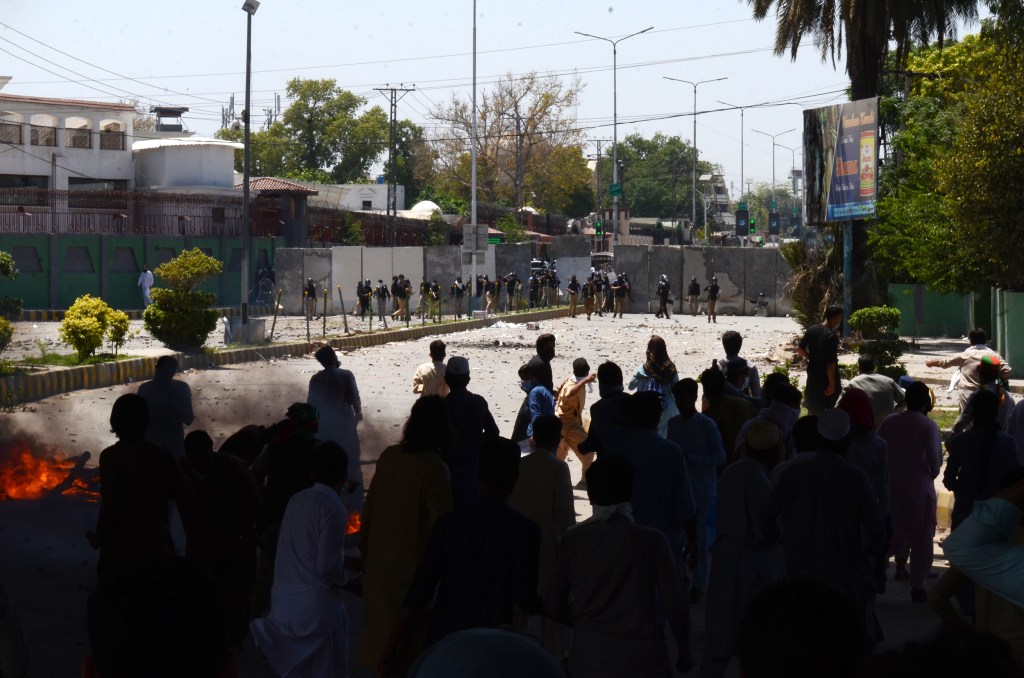 PESHAWAR, PAKISTAN - MAY 10: Pakistan Tehreek-e-Insaf (PTI) party activists and supporters of former Pakistan's Prime Minister Imran Khan, clash with police during a protest against the arrest of their leader in Peshawar on May 10, 2023. Khan appeared in a special court at the capital's police headquarters on May 10 to answer graft charges, local media reported, a day after his arrest prompted violent nationwide protests. Protesters burned tyres and vehicles to block the road. Security forces use tear gas to disperse the crowd. (Photo by Hussain Ali/Anadolu Agency via Getty Images)