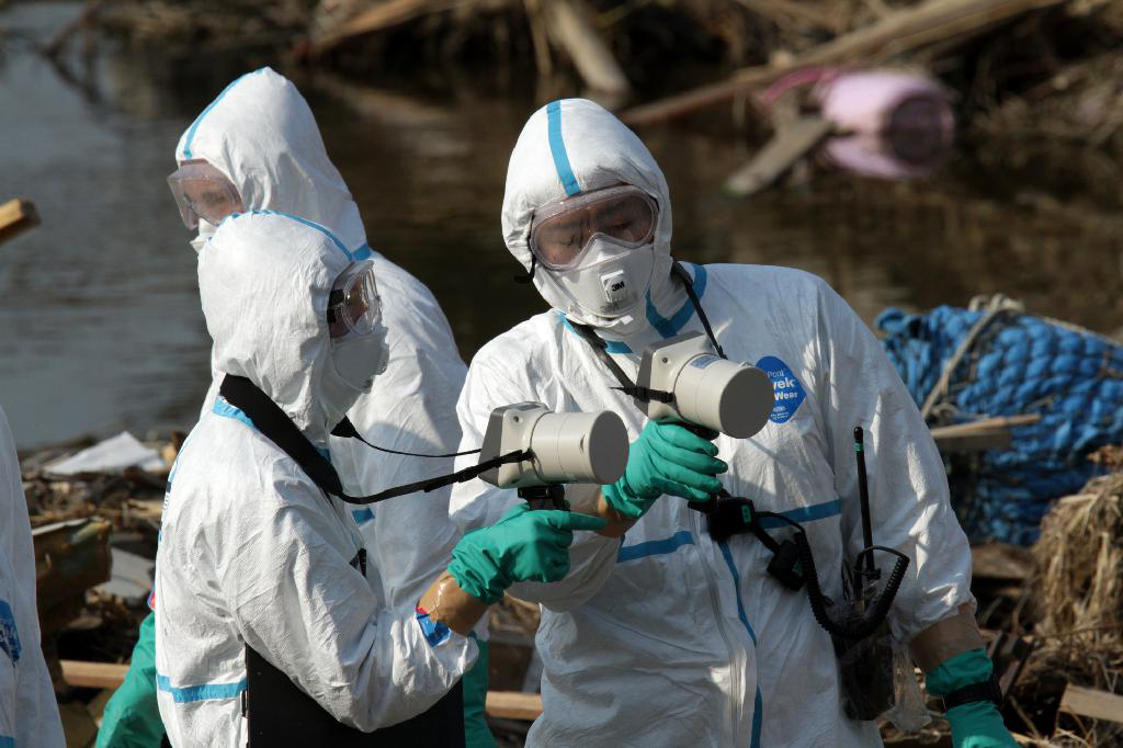 Fukushima Prefecture Police officers check geiger counters while searching for bodies of victims of the tsunami amongst rubble on April 14th, 2011.