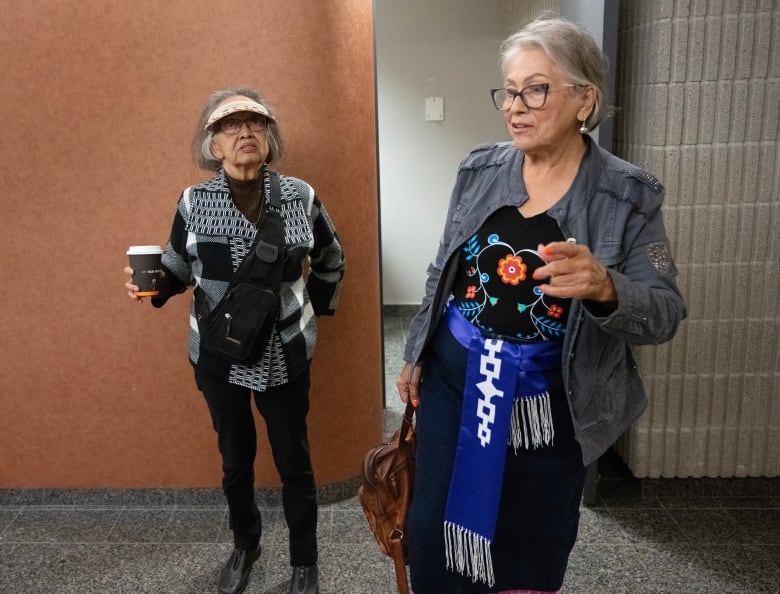 Two older women in a courtroom hallway