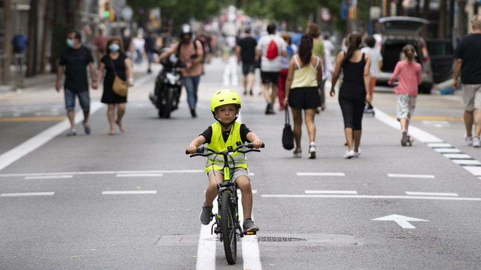 A boy rides a bicycle on a road turned into a pedestrian street on weekends in Barcelona