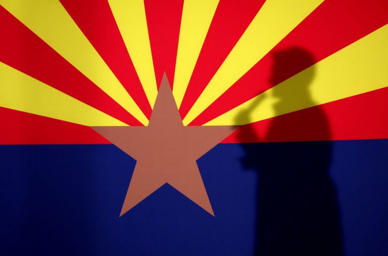 PRESCOTT, AZ - NOVEMBER 07: The shadow of Arizona Republican gubernatorial candidate Kari Lake is cast onto the Arizona state flag as she speaks during a get out the vote campaign rally on November 07, 2022 in Prescott, Arizona. With 1 days to go until election day, Kari Lake and other Republican candidates campaigning throughout the state ahead of Tuesday's midterm election. (Photo by Justin Sullivan/Getty Images) (Photo by Justin Sullivan/Getty Images)