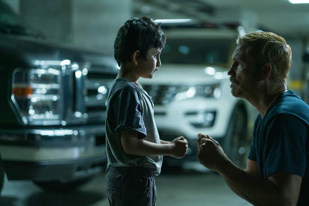 A man kneels in front of a child. 