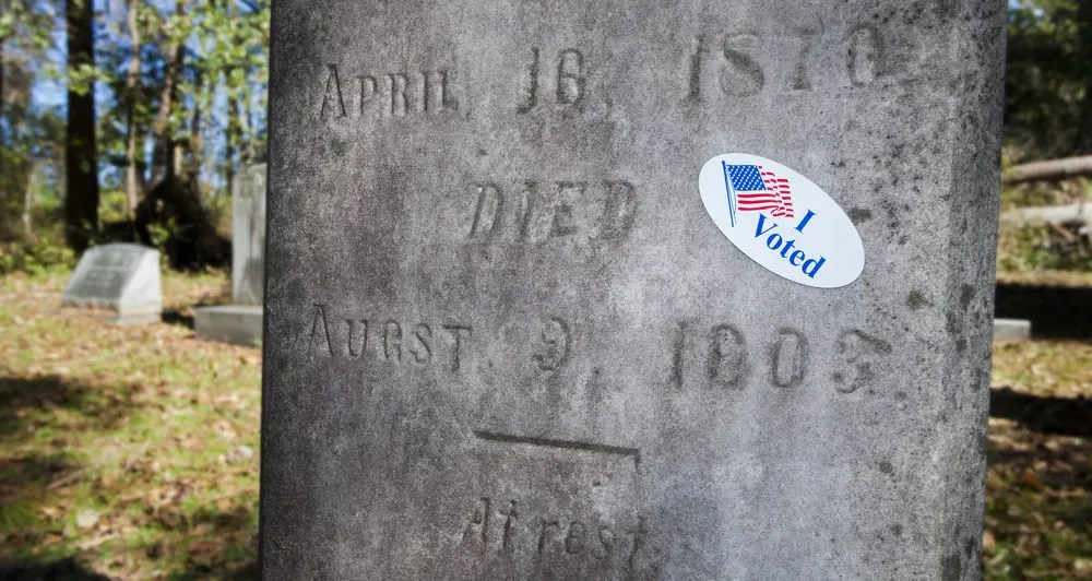 tombstone with voting sticker (Guy J. Sagi/Shutterstock) voters