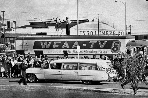 People line the street as the hearse bearing the body of US. President John F. Kennedy drives past.